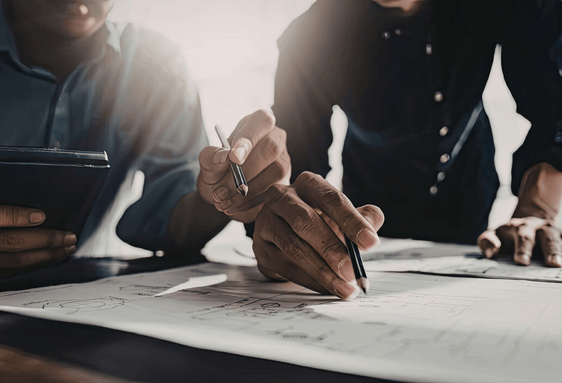 Two men filling out a building regulation application to ensure their house extension is safe and regulatory.